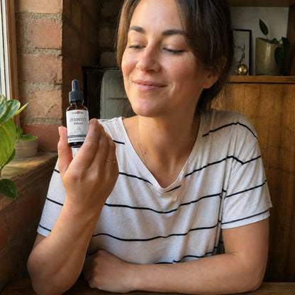 Donna che tiene in mano un flacone di olio di CBD Zermatt in un ambiente domestico accogliente